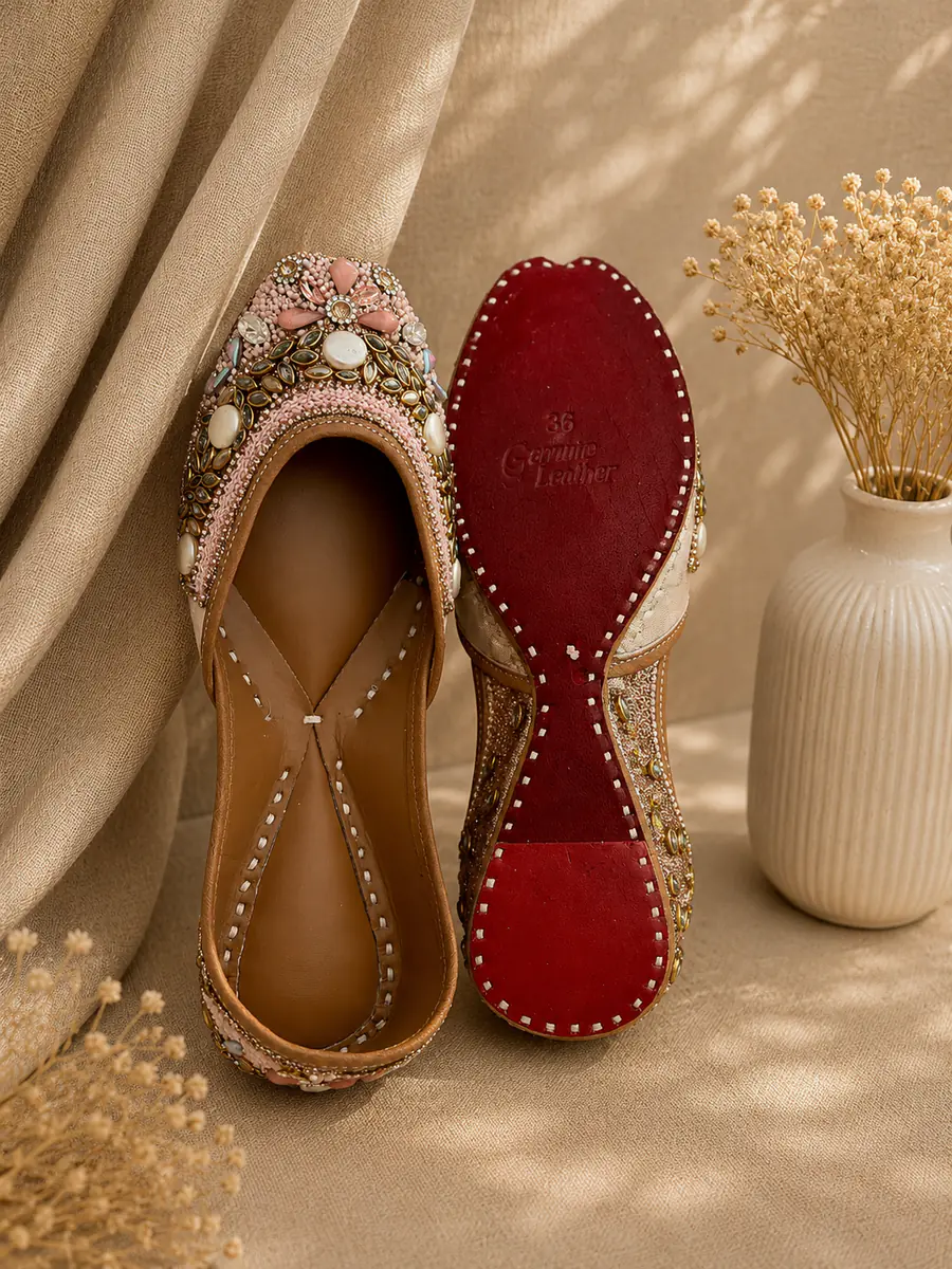 Blush Royal jutti stood beside its red leather sole, stamped Genuine Leather.