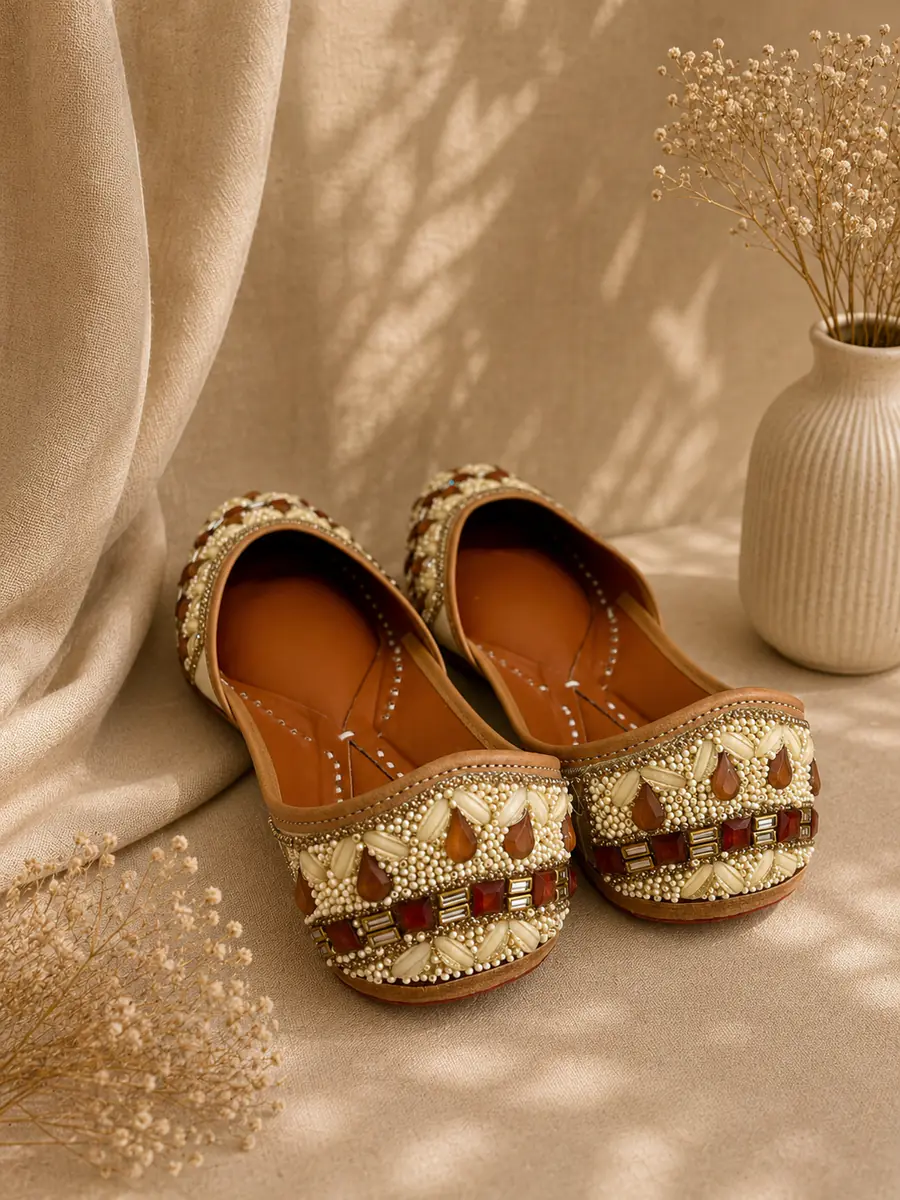 Royal Ember juttis seen from behind, the gold and garnet beadwork visible across each toe.